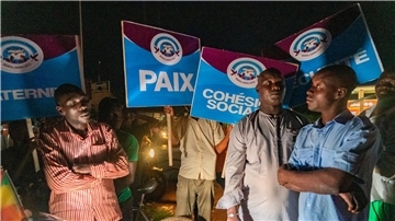 Anhänger der Militärjunta im Niger stehen an einem Kreisverkehr in Niamey und halten Wache.