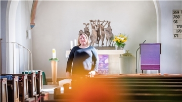 Anika Langer steht vor dem Altar in einer Kirche.