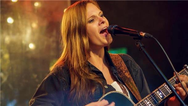 Eine Frau mit Gitarre singt