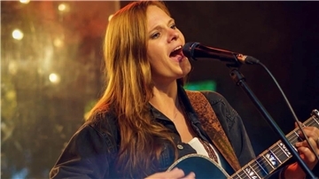 Eine Frau mit Gitarre singt