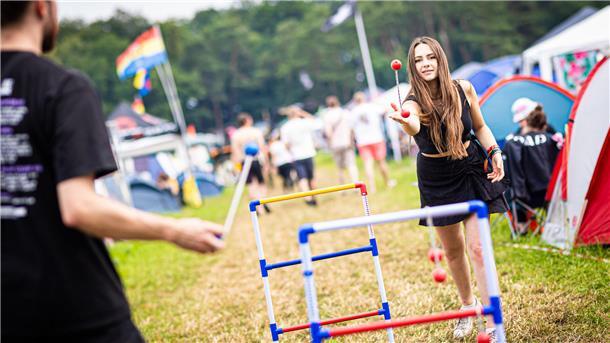Erst Sonne, dann plötzlich Starkregen und Matsch: Der Hurricane-Freitag in Bildern Anna (r) spielt auf dem Zeltplatz des Hurricane Festivals ein Wurfspiel.