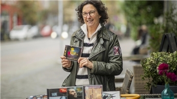 Eine Frau hält eine CD in der Hand.