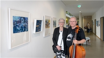 Kunstwerke an der Wand, Frau und Mann mit Instrument