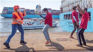 Annette Moritz (links) tanzt mit der Crew der „Maersk Brani“ auf der Kaje zur Musik, die an Bord der „Geestemünde“ nur für sie gespielt wird. Die Seemannsmission hat zum „Tag der Seefahrer“ die roten T-Shirts verschenkt und mahnt: Denkt mehr an die Seeleute.