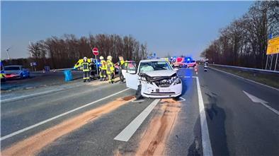 Ein weißer PKW nach einem Unfall auf einer Landstraße mit vielen Helfern der Feuerwehr.  