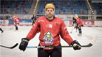 Eishockeyspieler Antti Tyrväinen mit Schläger und Ausrüstung.