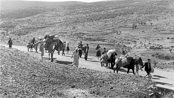Arabische Flüchtlinge gehen mit ihren Kindern und Habseligkeiten im Gepäck am 9. November 1948 auf einer staubigen Straße von Jerusalem in den Libanon. Die Staatsgründung Israels war 1948 für Hunderttausende von Palästinensern mit Vertreibung und dem Verlust von Heimat verbunden.