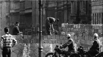 Arbeiter erhöhen die Sektorensperre an der Bernauer Straße in Berlin. Mit dem Bau am 13. August wurde vor 62 Jahren begonnen.
