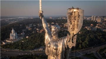 Arbeiter montieren das ukrainische Staatswappen auf das Schild in der Hand des Mutter-Heimat-Denkmals in Kiew, nachdem zuvor die sowjetischen Symbole entfernt worden waren.