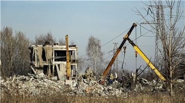 Arbeiter räumen Trümmer nach einem ukrainischen Raketeneinschlag in der von Russland besetzten Stadt Makijiwka weg.