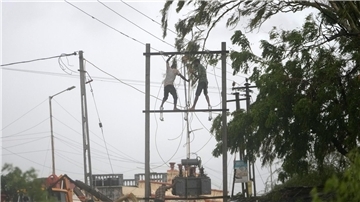 Arbeiter reparieren in Indien einen Transformator, um die Stromversorgung wiederherzustellen.