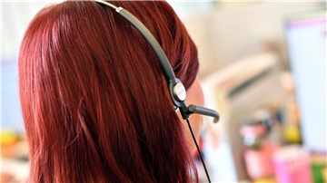 Eine Frau mit Headset telefoniert.