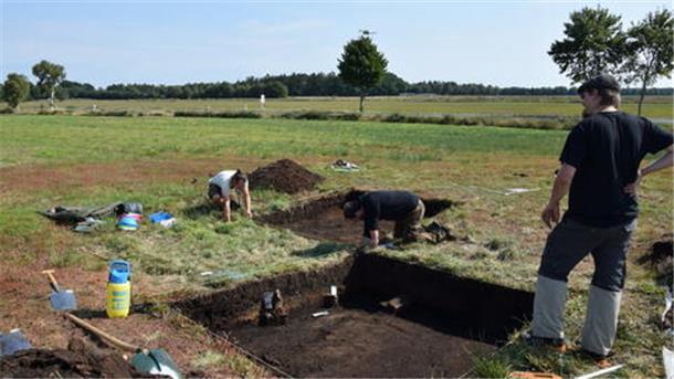 Archäologen bei Freilegungsarbeiten zweier Quadranten einer Abfallgrube in Sandbostel.  