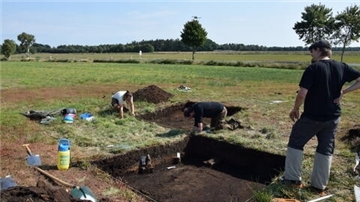 Archäologen bei Freilegungsarbeiten zweier Quadranten einer Abfallgrube in Sandbostel.  
