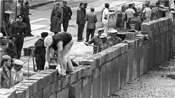 ARCHIV - 18.08.1961, DDR, Berlin: Unter der Aufsicht von bewaffneten Volkspolizisten errichtet eine Ostberliner Maurerkolonne am an der sowjetisch-amerikanischen Sektorengenze am Potsdamer Platz eine Mauer. (zu "Baubeginn der Berliner Mauer vor 59 Jahren") Foto: UPI/dpa +++ dpa-Bildfunk +++
