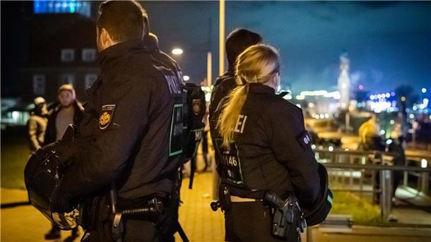 Archivbild: Silvester am Deich 2019/20. Reportage mit Feuerwerk und Besuchern am Neuen Hafen. Im Bild: Polizeibeamte sichern auf dem Deich zur Weserseite und Innenstadt das Feuerwerk ab. Foto: Hartmann