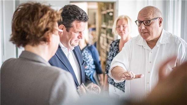 Astro-Chef Thomas Graudenz (rechts, im Hintergrund seine Ehefrau Andrea) ist voll in seinem Element, als er Niedersachsens Gesundheitsministerin Daniela Behrens (SPD, links) und Bundesarbeitsminister Hubertus Heil (SPD) die Motorenproduktion am Standort Debstedt erklärt.