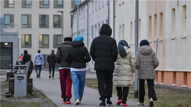 Schlagabtausch vor Asylgipfel Asylsuchende gehen über das Gelände der Zentralen Erstaufnahmeeinrichtung für Asylbewerber des Landes Brandenburg in Eisenhüttenstadt.