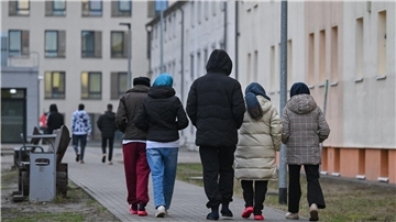 Asylsuchende gehen über das Gelände der Zentralen Erstaufnahmeeinrichtung für Asylbewerber des Landes Brandenburg in Eisenhüttenstadt.