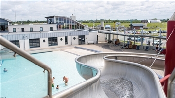 Das Wellenfreibad Watt'n Bad mit Blick von der silbernen Rutsche. Links ist das Schwimmbecken zu sehen.