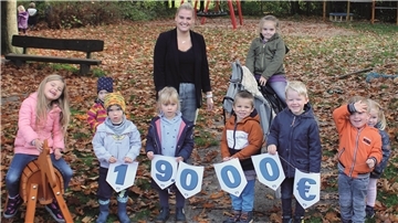Auf dem Bild sind Kinder der Kita Regenbogendland in Bokel sowie Julia Pzrybilowski, Sprecherin der Volksbank, zu sehen.