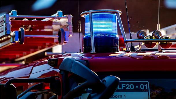 Auf dem Dach eines Einsatzfahrzeugs der Feuerwehr leuchtet ein Blaulicht.