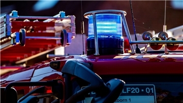 Auf dem Dach eines Einsatzfahrzeugs der Feuerwehr leuchtet ein Blaulicht.