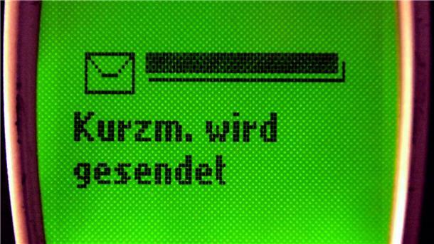 Auf dem Display eines alten Mobiltelefons steht „Kurzm. wird gesendet“.