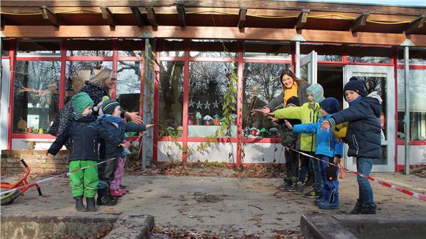 Zwei Kindergartengruppen stehen sich mit viel Abstand gegenüber.