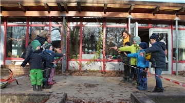 Zwei Kindergartengruppen stehen sich mit viel Abstand gegenüber.