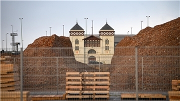Gebäude ragt zwischen Schuttbergen hervor. 