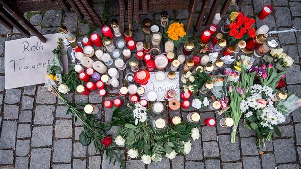 Blumenverkäuferin getötet: 17-jähriger Verdächtiger gefasst Auf dem Platz vor dem Blumengeschäft sind Blumen und Kerzen als Zeichen der Trauer niedergelegt.