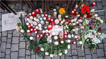 Auf dem Platz vor dem Blumengeschäft sind Blumen und Kerzen als Zeichen der Trauer niedergelegt.