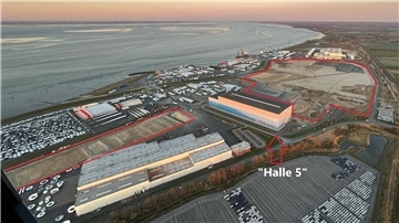 Blick auf den Cuxhavener Hafen - mit roten Markierungen. Auf der Fläche links (rot umrandet) entsteht eine neue 285 Meter lange und 62 Meter breite Fertigungshalle. Zwei weitere Hallen und das Schwerlastlager für Monopiles entstehen östlich der „Halle 5" im oberen Teil des Bildes. 