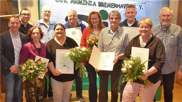 Mitglieder der DJK Arminia erhalten Urkunden und Blumen zur Ehrung.