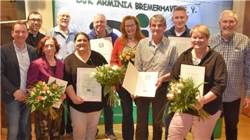 Mitglieder der DJK Arminia erhalten Urkunden und Blumen zur Ehrung.