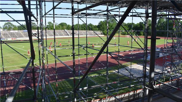 Auf der Tribüne des Nordseestadions steht ein Baugerüst, auf dem Platz läuft ein Jugendspiel.