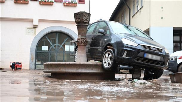 Süddeutschland ächzt unter dem Hochwasser Auf einem Brunnen in Rudersberg hängt ein durch das Hochwasser weggespültes Auto.