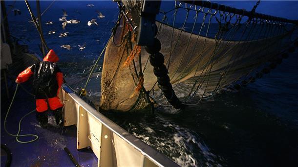 Auf einem Krabbenkutter werden am späten Abend auf der Nordsee die Netze eingeholt. Immer wieder finden die Fischer darin auch Müll.