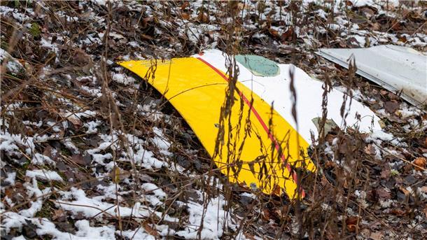 Ermittler bergen Flugschreiber nach Absturz in Litauen Auf einem Trümmerteil des abgestürzten Flugzeugs sind die DHL-Farben zu sehen.