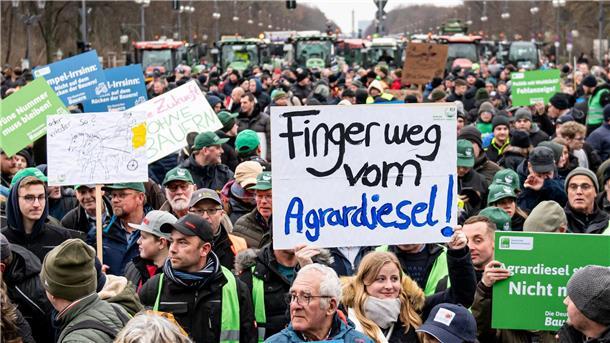 Auf einer Demonstration des Deutschen Bauernverbandes unter dem Motto „Zu viel ist zu viel! Jetzt ist Schluss!“ hält jemand ein Schild mit der Aufschrift „Finger weg vom Agrardiesel“ hoch.