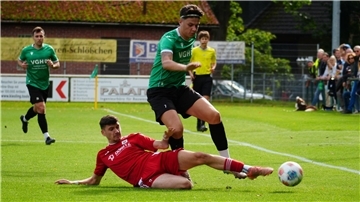 Ein Fußballer im Zweikampf mit einem Gegenspieler.
