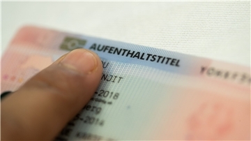 „Aufenthaltstitel“ steht auf einer „Blauen Karte“ für ausländische Fachkräfte.