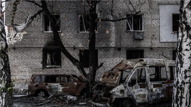 Augebrannte Autos vor einem schwer beschädigtem Wohnblock in der Frontstadt Orichiw.