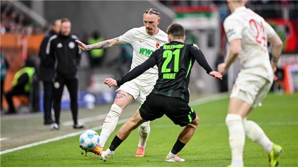 Augsburg schlägt Wolfsburg und rückt näher an Europacup ran Augsburgs Marius Wolf spielt den Ball an Joakim Maehle von Wolfsburg vorbei.