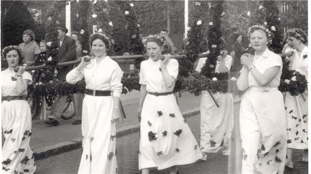 Frauen tragen auf einem Schwarz-Weiß-Foto aus den 50er-Jahren die Kronen für einen Pfingstbaum.