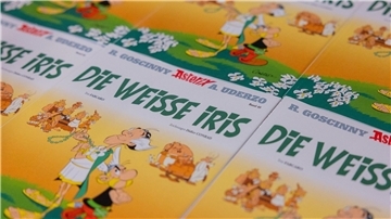 Ausgaben des neuen Asterix-Bandes mit dem Titel „Die weiße Iris“ werden in einer Logistikhalle konfektioniert und in Displays für den Einzelhandel verpackt.