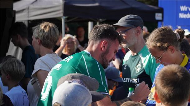 Werder All-Stars trumpfen beim Jubiläumsspiel der SG Beverstedt auf Werder-Oldie beim Autogrammschreiben