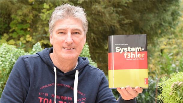 Autor Ron Michael Levy legt mit „Systemf3hler“ ein Sachbuch vor.