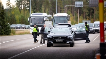 Autos und Busse stehen an der russisch-finnischen Grenze Schlange.